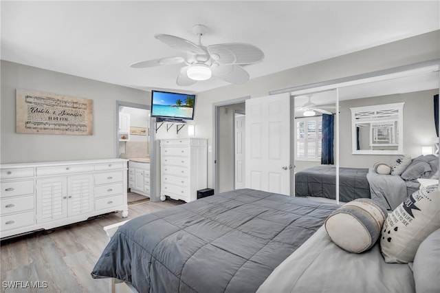 bedroom featuring light hardwood / wood-style floors, ensuite bathroom, a closet, and ceiling fan