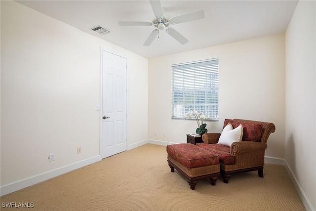 sitting room with light carpet, ceiling fan, visible vents, and baseboards