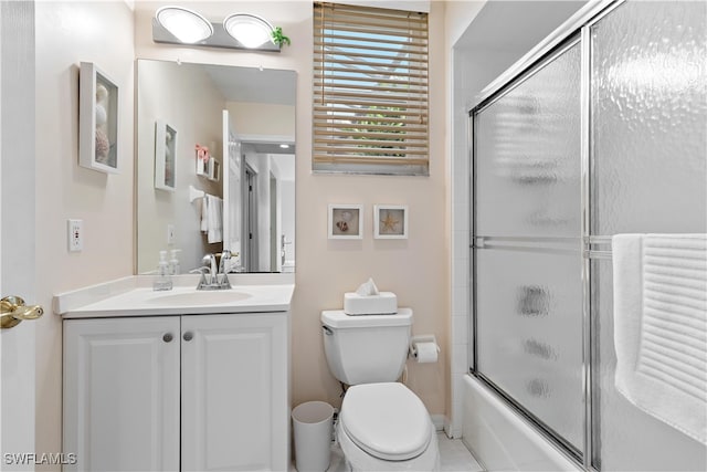 full bathroom with tile patterned floors, shower / bath combination with glass door, vanity, and toilet