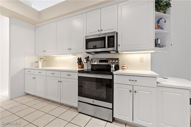 kitchen with white cabinets, light tile patterned flooring, appliances with stainless steel finishes, and backsplash