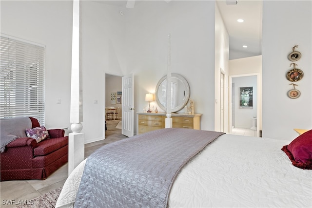 bedroom with a towering ceiling and light tile patterned floors