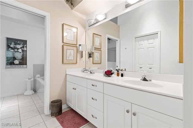 bathroom with tiled bath, vanity, and tile patterned floors