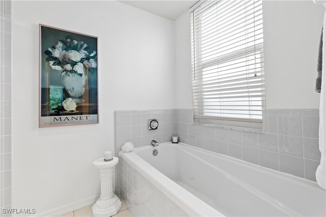 bathroom featuring a healthy amount of sunlight, tile patterned floors, and a relaxing tiled tub