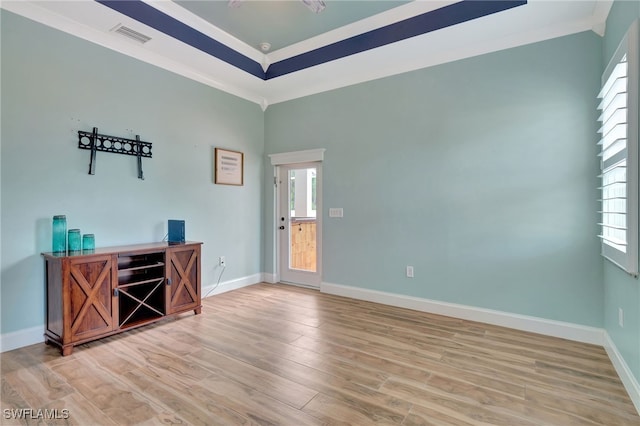 empty room with crown molding and light hardwood / wood-style flooring