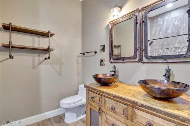 bathroom featuring toilet, vanity, and hardwood / wood-style flooring