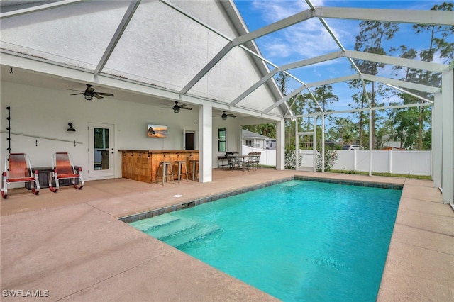 view of swimming pool featuring a lanai, a patio area, and a bar