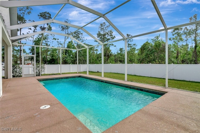 view of swimming pool featuring a yard, a patio area, and a lanai