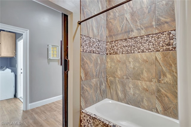 bathroom featuring hardwood / wood-style floors, bathing tub / shower combination, and washing machine and clothes dryer