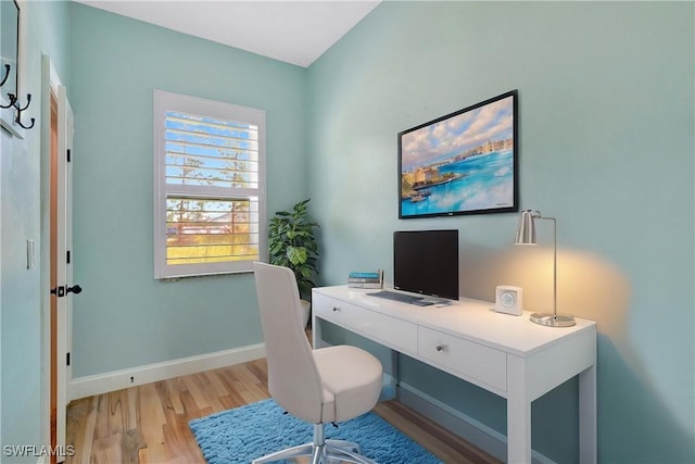 home office with light hardwood / wood-style floors