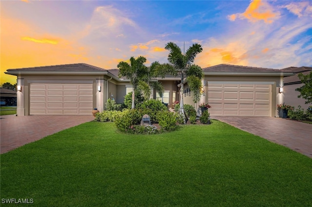 ranch-style home with a yard and a garage