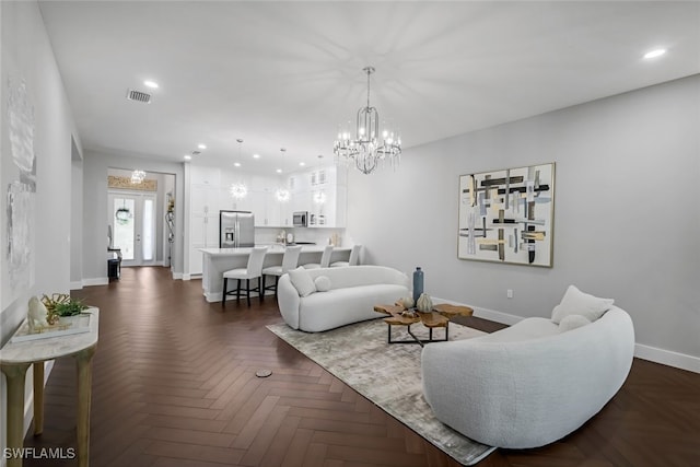 living area with baseboards, an inviting chandelier, visible vents, and recessed lighting