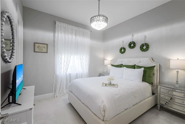 carpeted bedroom featuring an inviting chandelier