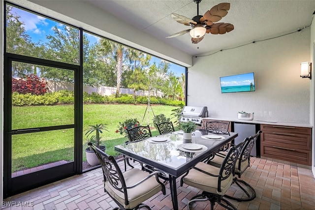 sunroom / solarium featuring ceiling fan