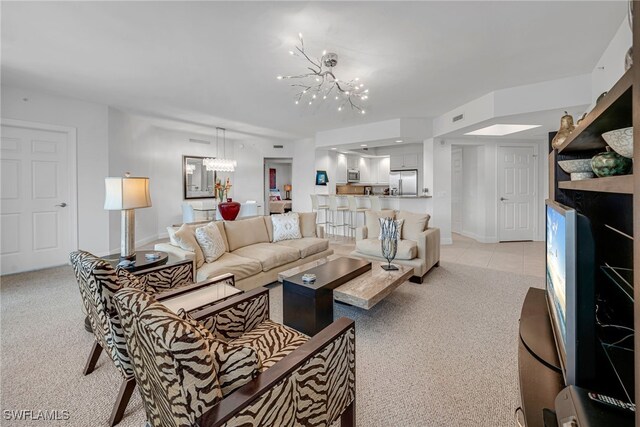 living area featuring visible vents, a notable chandelier, light colored carpet, and baseboards