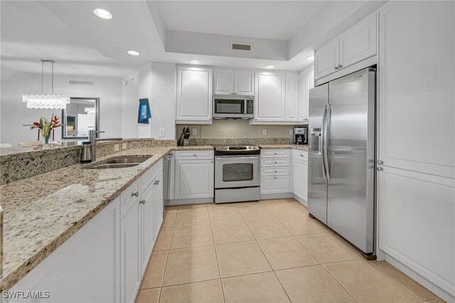 kitchen featuring visible vents, a sink, stainless steel appliances, white cabinets, and light tile patterned floors