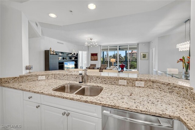 kitchen featuring dishwasher, an inviting chandelier, white cabinets, and a sink