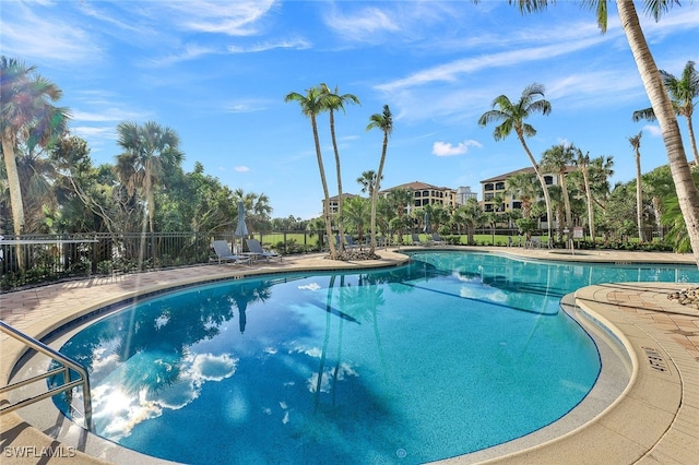 pool with a patio area and fence