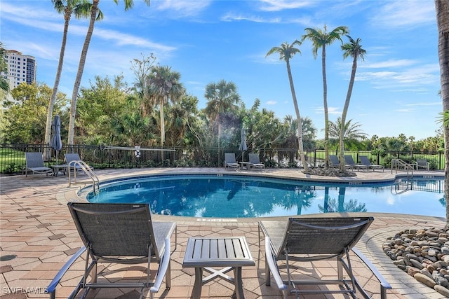 pool with a patio area and fence