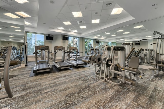 gym with visible vents, a tray ceiling, and a drop ceiling