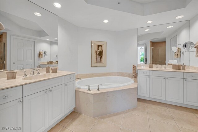 bathroom featuring tile patterned floors, a shower stall, a garden tub, and a sink