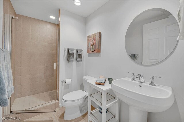 full bathroom featuring toilet, a stall shower, a sink, recessed lighting, and tile patterned flooring