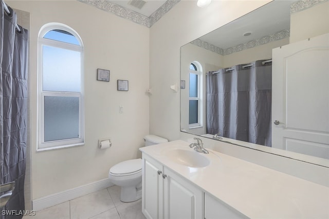 bathroom with vanity, tile patterned flooring, toilet, and walk in shower