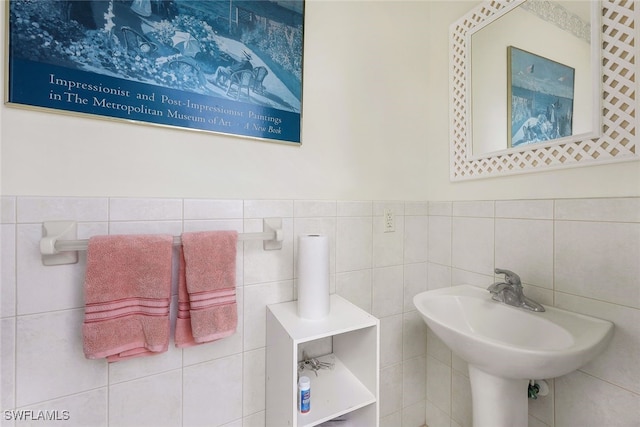 bathroom featuring tile walls and sink