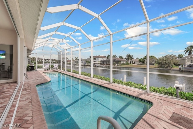 view of swimming pool featuring a water view, a patio, and glass enclosure