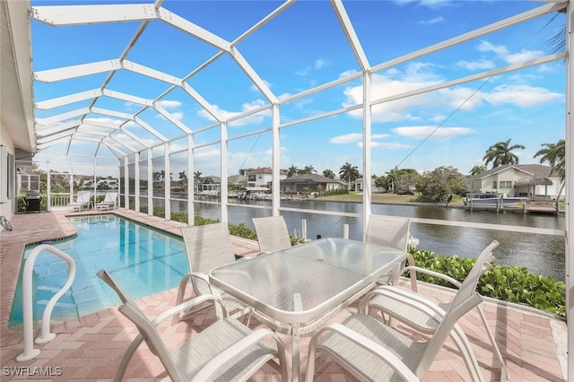 view of pool featuring a lanai, a water view, and a patio area