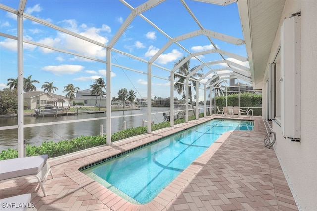 view of swimming pool featuring a water view, glass enclosure, and a patio area