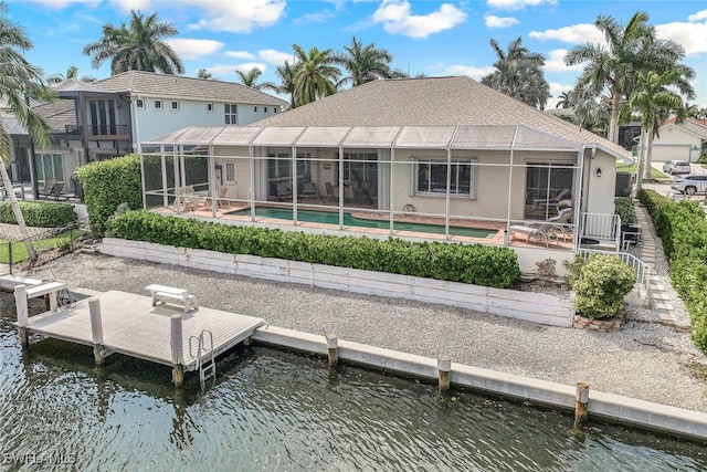 back of property featuring a water view, glass enclosure, and a patio area