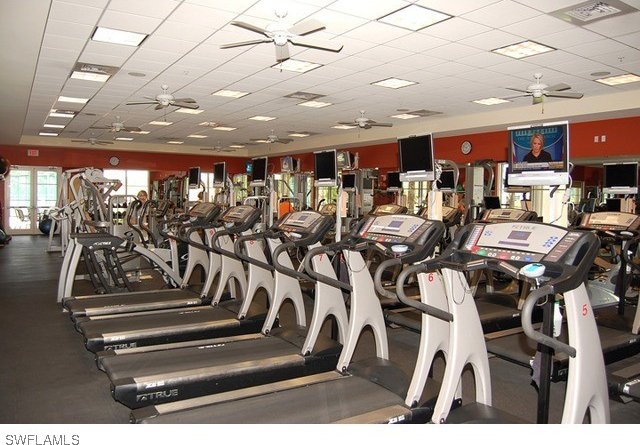 gym with ceiling fan and a paneled ceiling