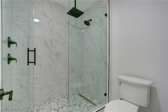 bathroom featuring walk in shower and toilet