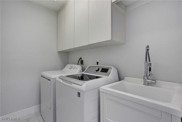 laundry area with cabinets, washer and dryer, and sink