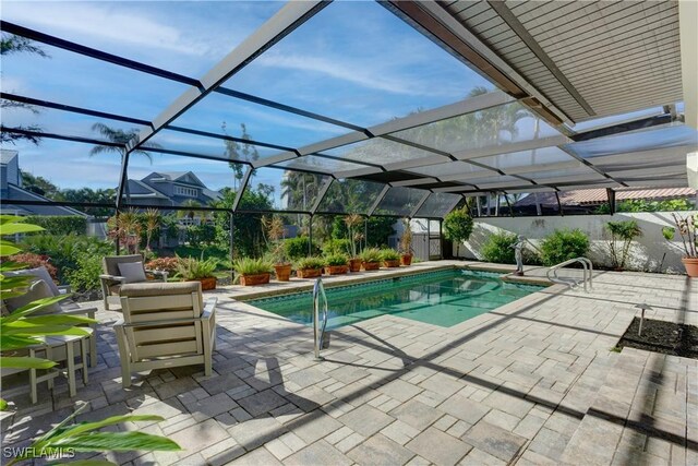 view of swimming pool featuring a patio and a lanai