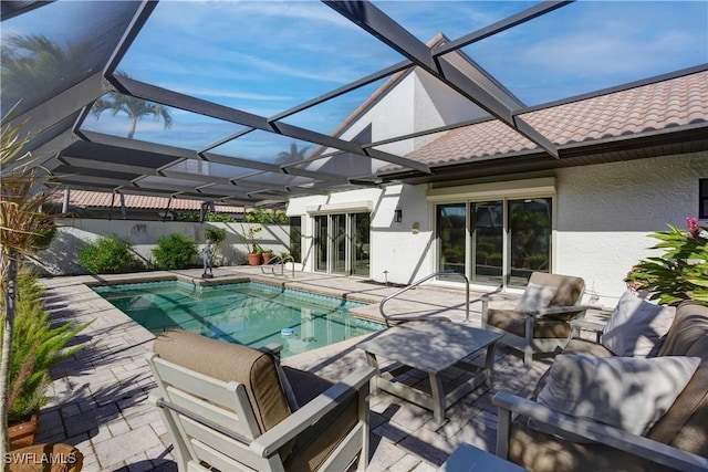 view of pool featuring glass enclosure and a patio area