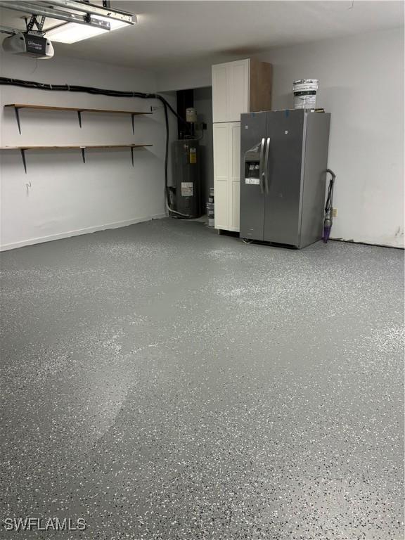 garage featuring stainless steel fridge with ice dispenser, a garage door opener, and electric water heater