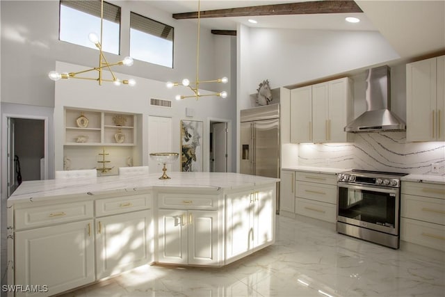 kitchen featuring a chandelier, pendant lighting, a kitchen island, wall chimney range hood, and stainless steel appliances