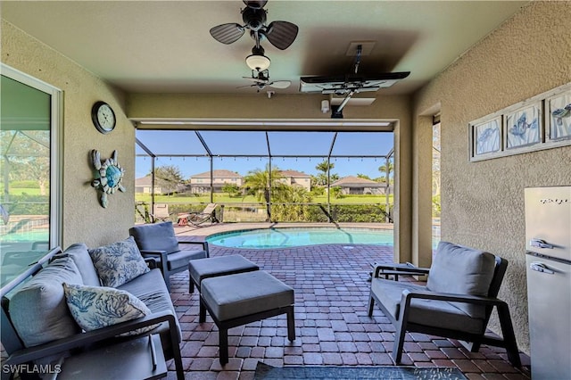 view of patio / terrace with ceiling fan, an outdoor hangout area, and glass enclosure