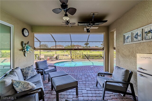 view of patio / terrace with a lanai, ceiling fan, and outdoor lounge area