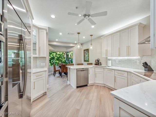 241 Colonade Cir, Naples, FL 34103 - kitchen featuring appliances with stainless steel finishes, a peninsula, light wood-style flooring, decorative backsplash, and ceiling fan