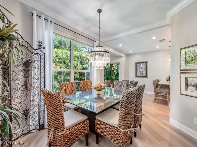 dining space featuring a notable chandelier, light wood-type flooring, and crown molding