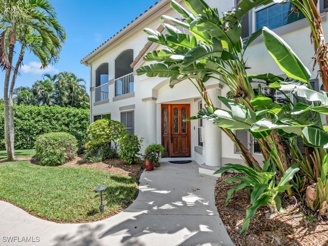 241 Colonade Cir, Naples, FL 34103 - view of exterior entry featuring stucco siding and a balcony