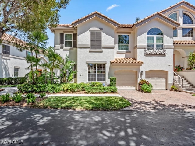 241 Colonade Cir, Naples, FL 34103 - mediterranean / spanish house featuring a tiled roof, a garage, decorative driveway, and stucco siding