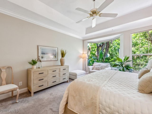 241 Colonade Cir, Naples, FL 34103 - bedroom featuring light colored carpet, a tray ceiling, crown molding, baseboards, and ceiling fan