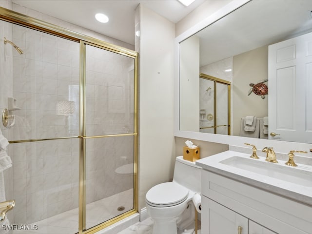 bathroom featuring vanity, toilet, and a shower with shower door