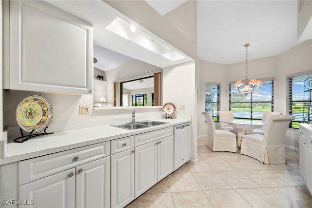 kitchen featuring light tile patterned floors, sink, dishwasher, a notable chandelier, and white cabinets