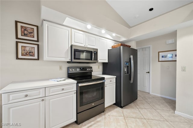 kitchen featuring stainless steel appliances, lofted ceiling, and white cabinets