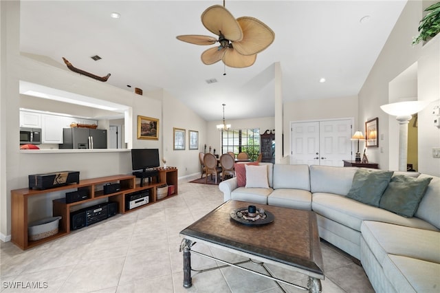 tiled living room with ceiling fan with notable chandelier and vaulted ceiling