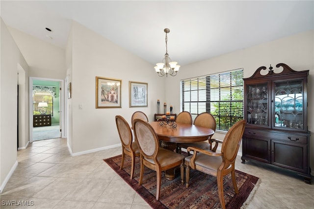 tiled dining room featuring an inviting chandelier and vaulted ceiling